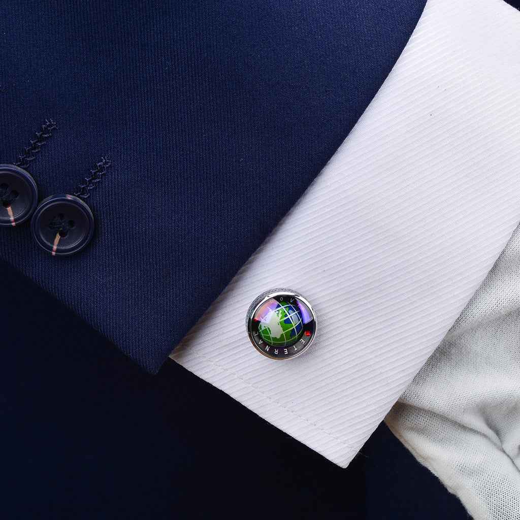 Rotating earth globe cufflinks on white shirt cuffs, silver circular frame