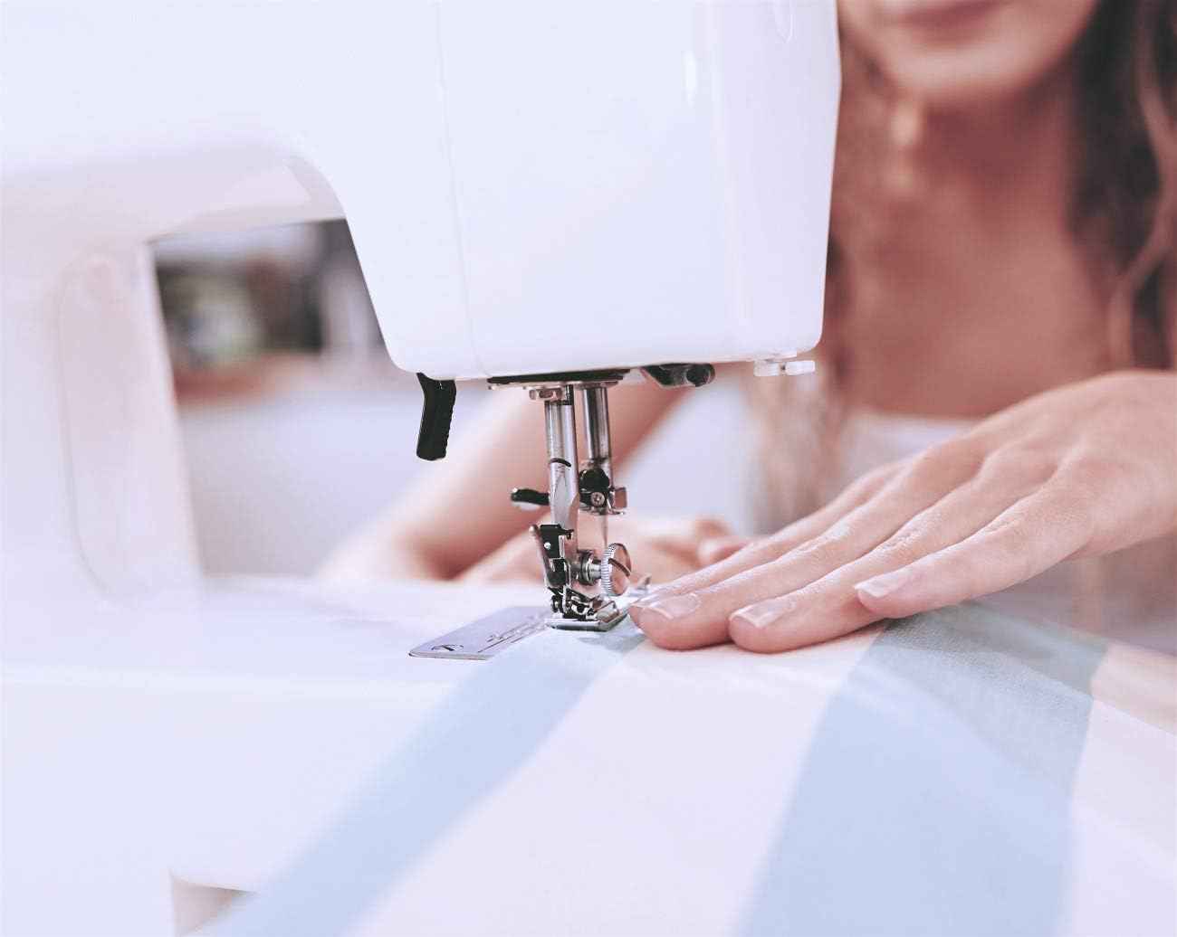 Sewing machine using a rolled hem presser foot to stitch a folded fabric edge