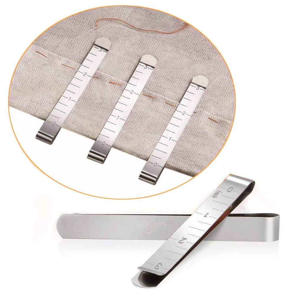 Stainless hemming clip ruler guides on cloth, showing inch markings for even hems