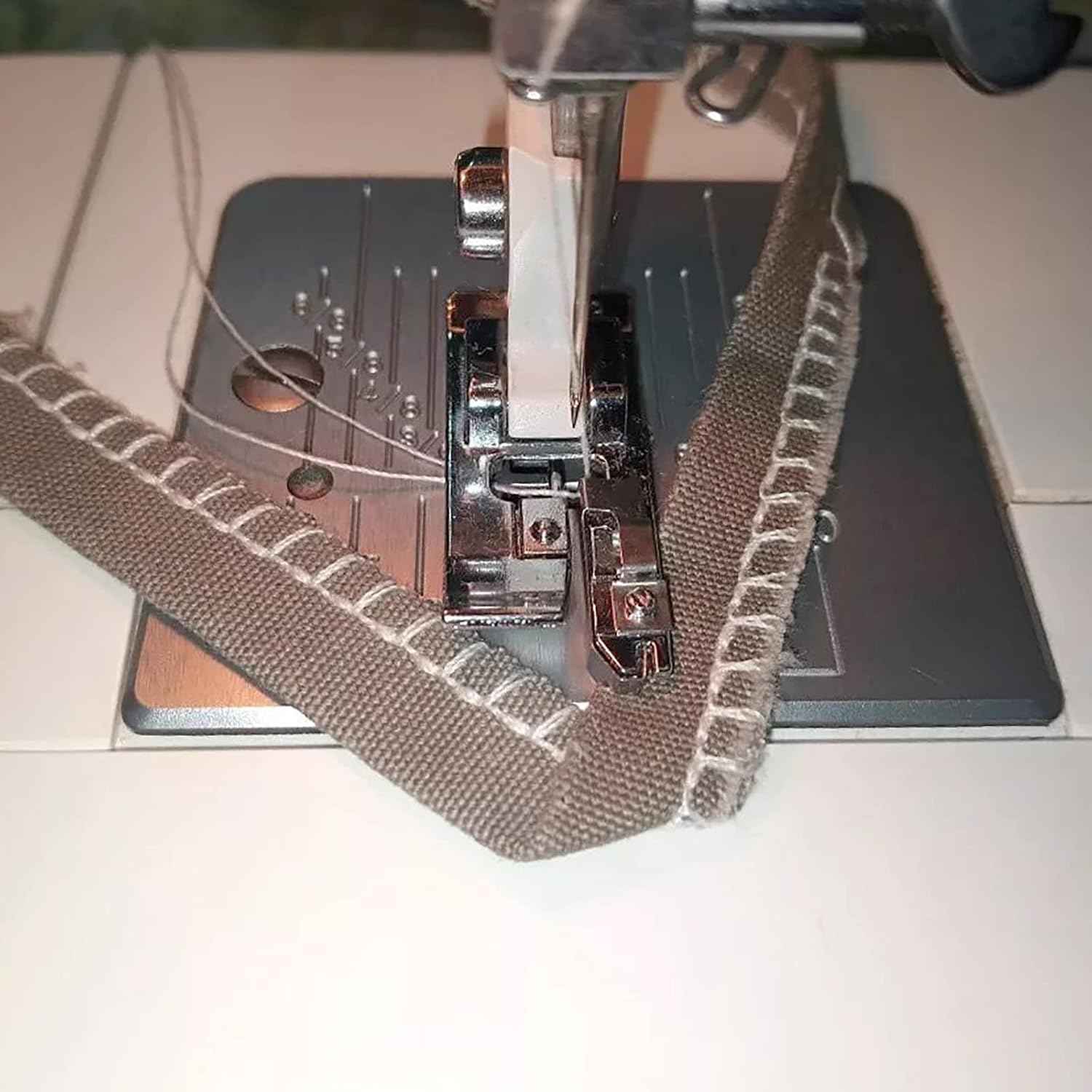 Overcast presser foot sewing along fabric edge, guiding fabric for neat overcast stitching