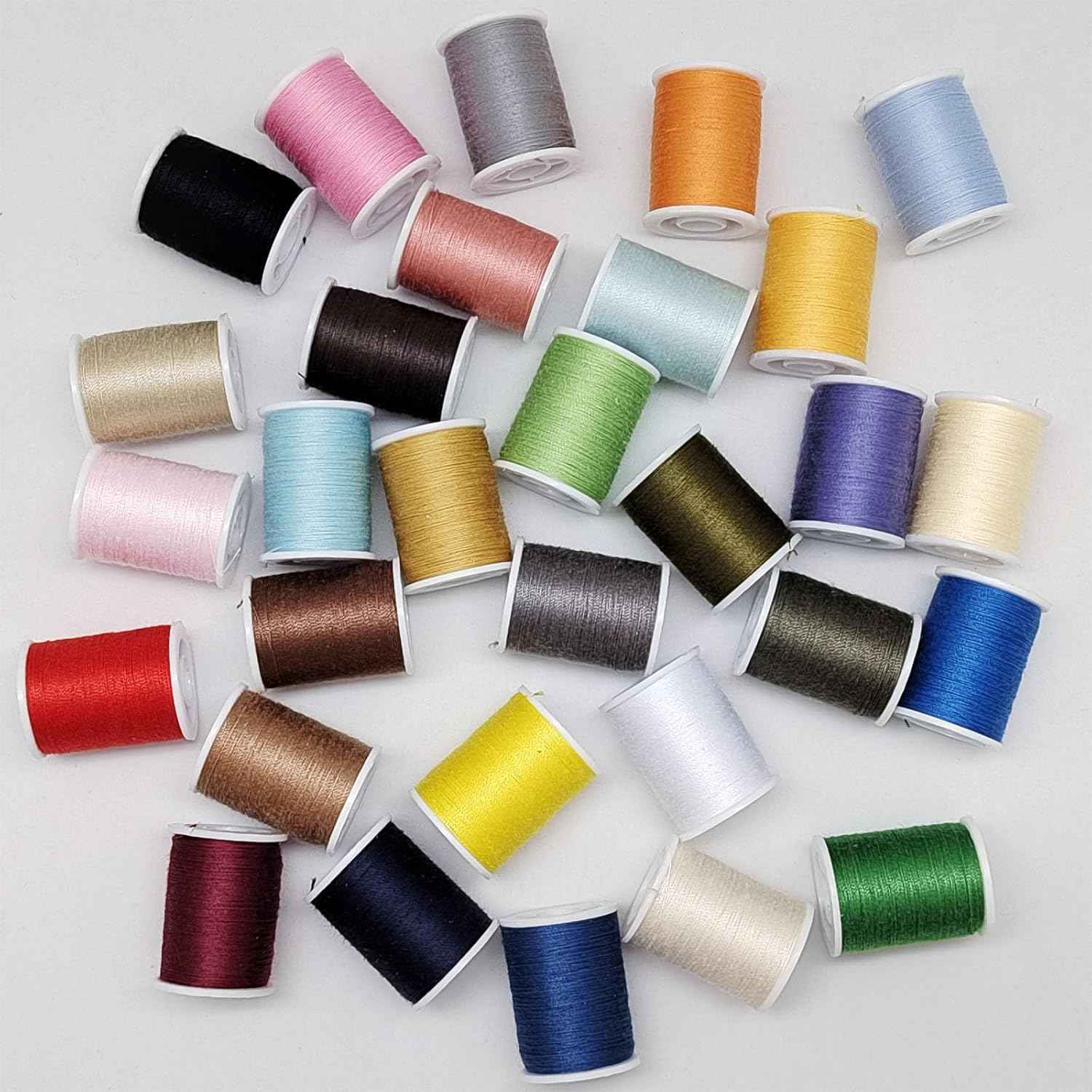 Assorted polyester sewing thread spools in multiple colors with white thread bobbins