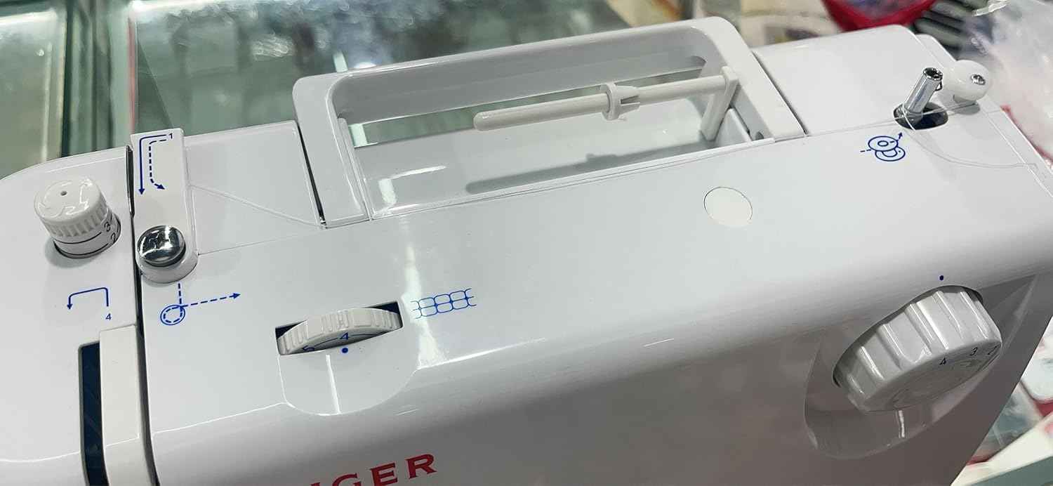 Spool pin cap set installed on sewing machine top, showing cap and pin area