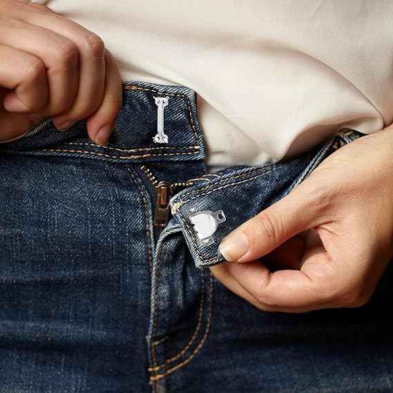 Metal trouser hook fastener snapped into place on denim with hands