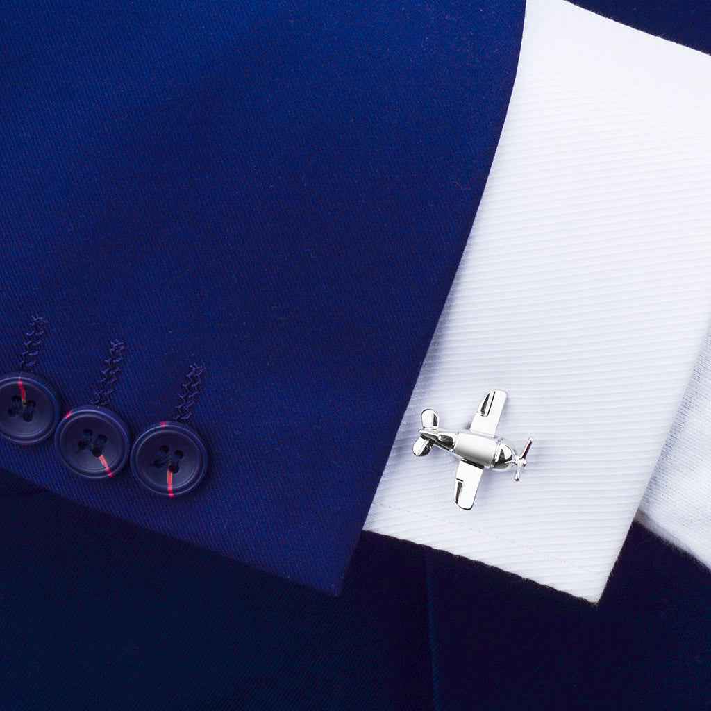 Aircraft bomber cufflink on a shirt cuff, silver-tone metal