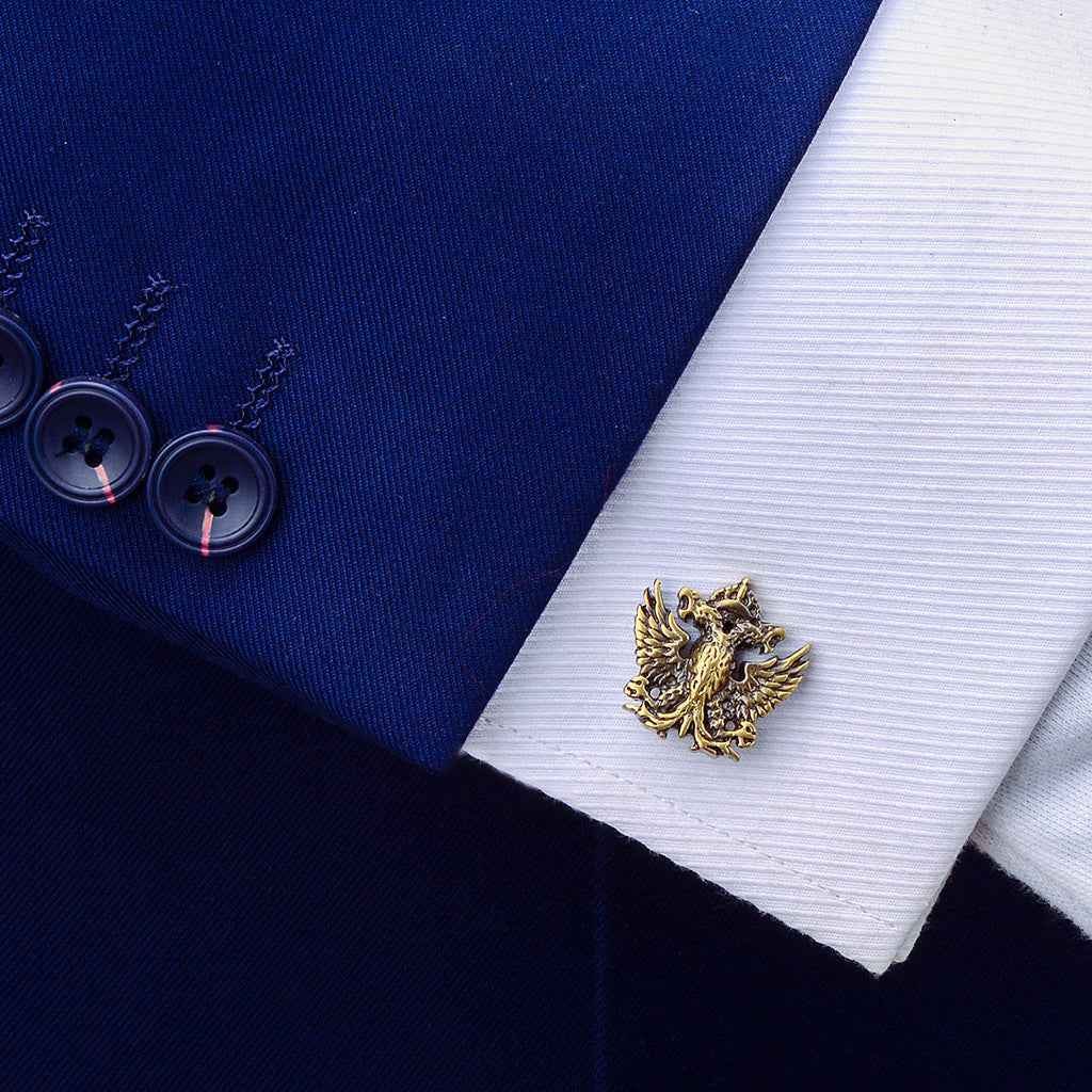 Double-headed eagle cufflink on white shirt cuff, antique bronze winged emblem