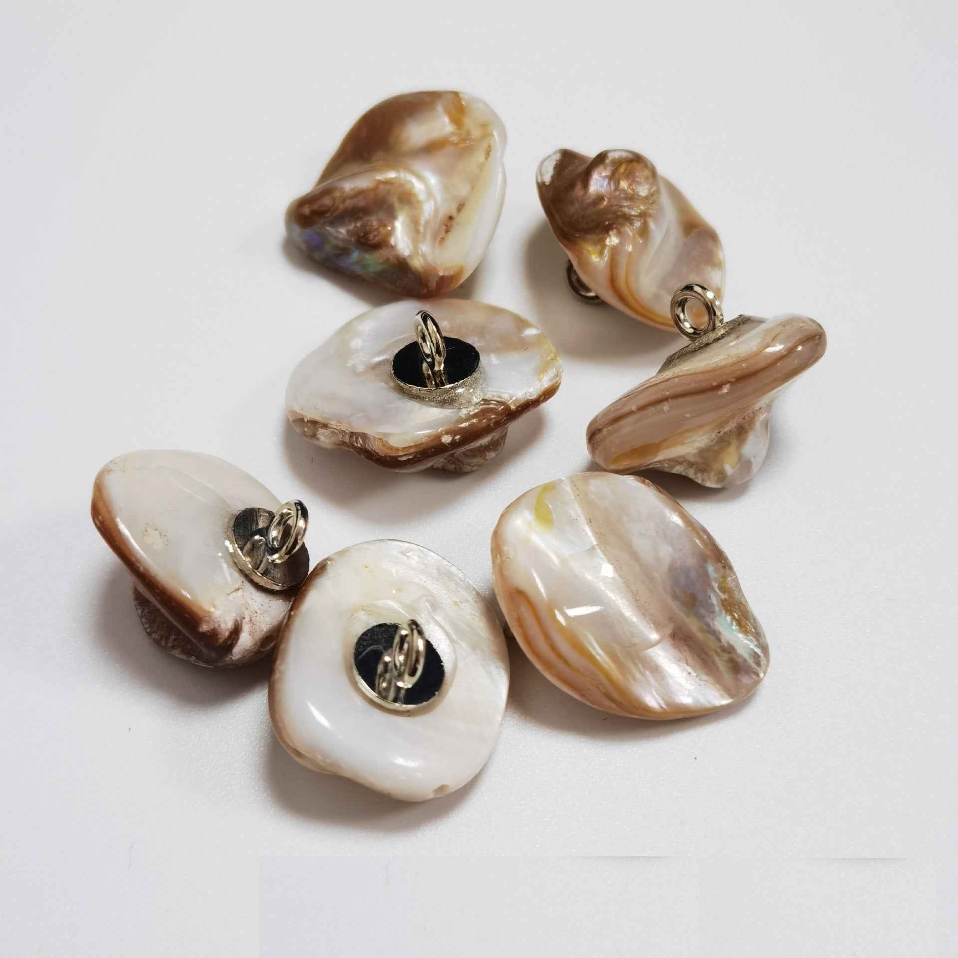 Cream/white irregular shell shank buttons with metal loop shanks, glossy pearly.
