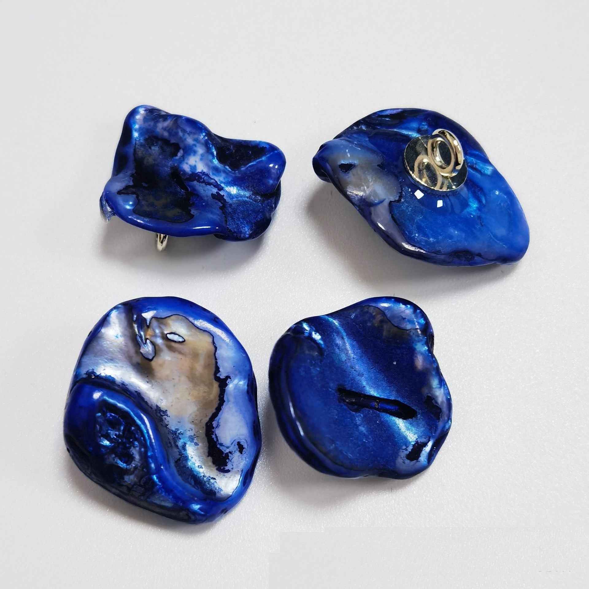 Deep blue irregular shell shank buttons with metal loop shanks, glossy natural pattern.