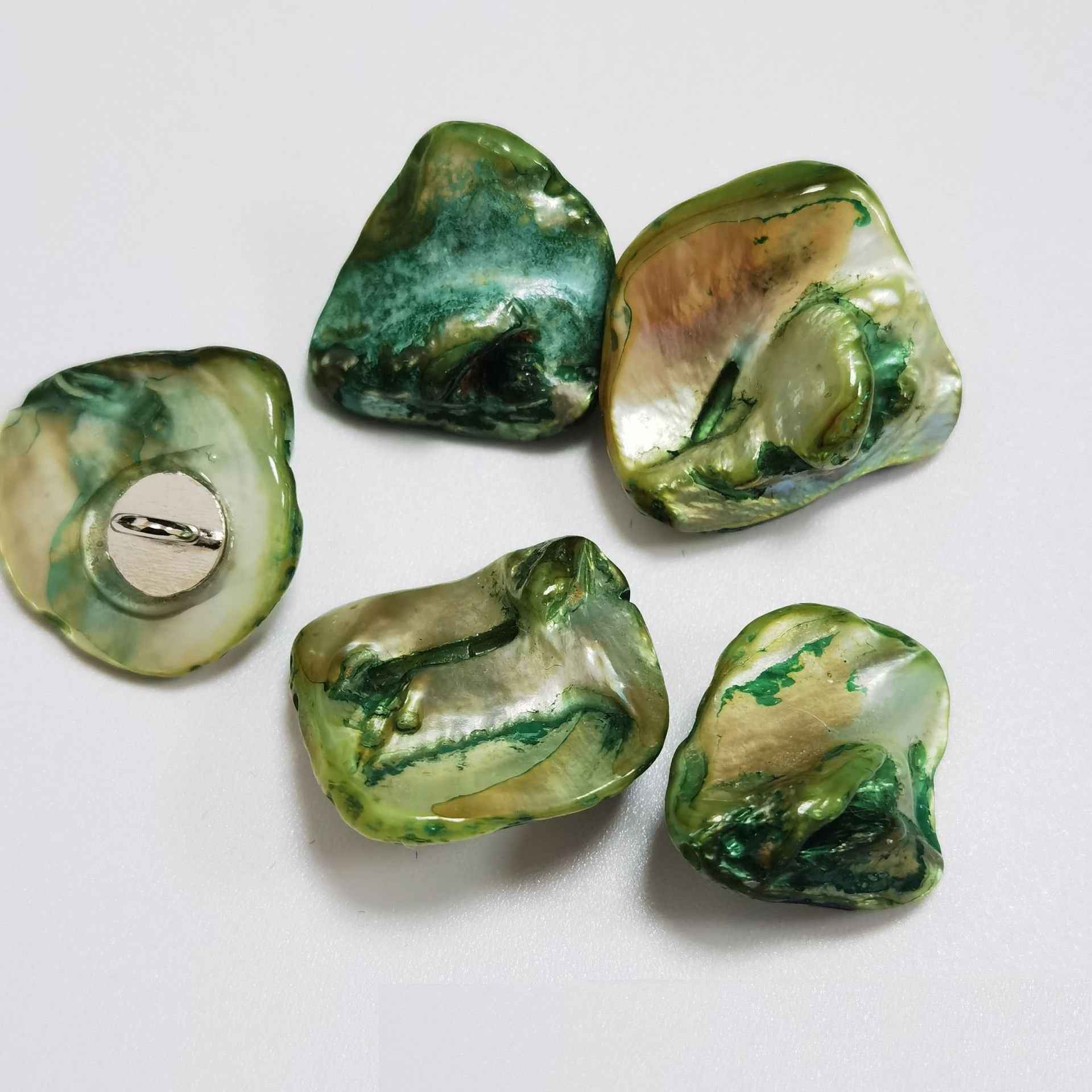 Green/yellow irregular shell shank buttons with metal loop shanks, glossy pearly finish.