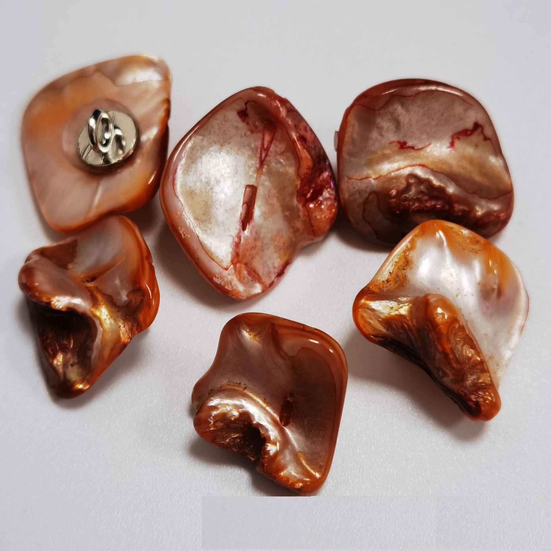 Brown/caramel irregular shell shank buttons with metal loop shanks, glossy organic shapes.
