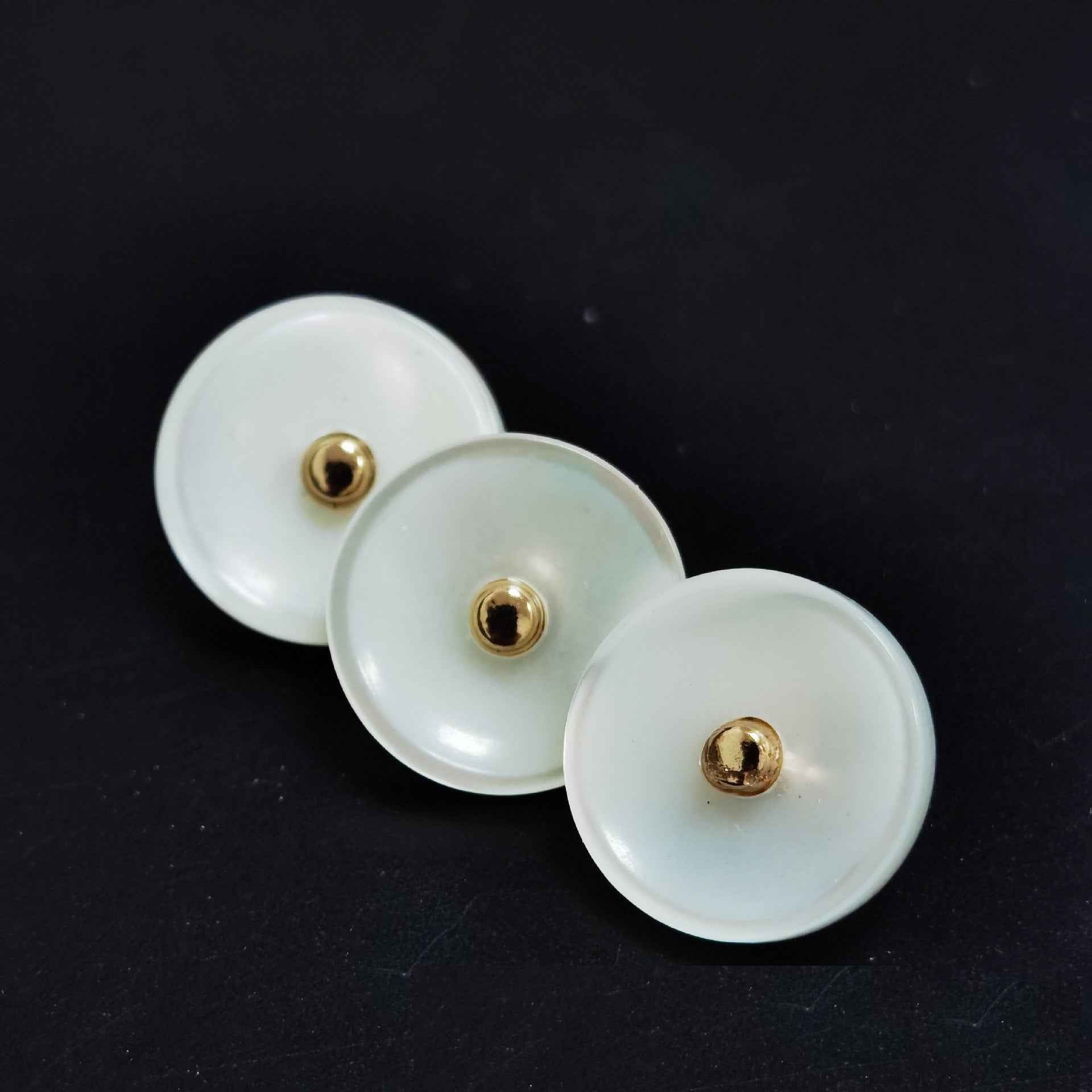 Ivory mother-of-pearl shank buttons with gold-tone metal backing, close-up of 3
