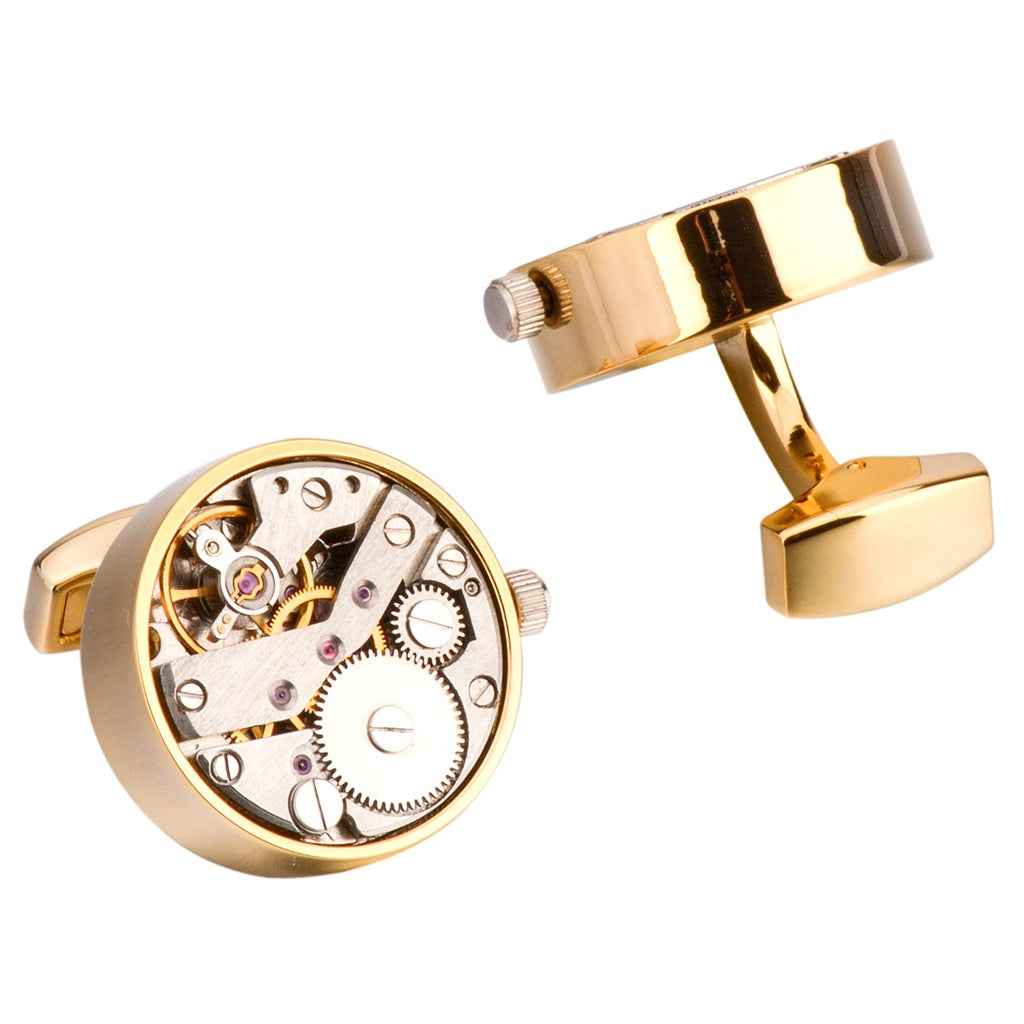 Gold mechanical watch movement cufflinks, close-up of round face with hinge and clasp