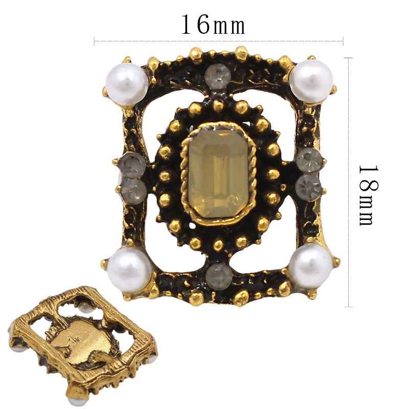 Gold-and-black shank button with rectangular center stone, pearls, and smoky side stones