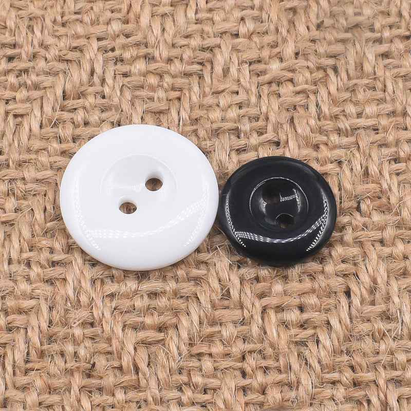 White and black round 2-hole resin buttons side by side, glossy finish and threaded holes