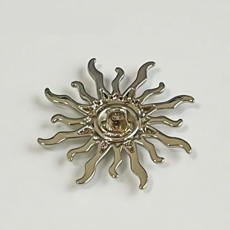 Close-up sun-shaped metal shank button, silver-tone with reflective round center