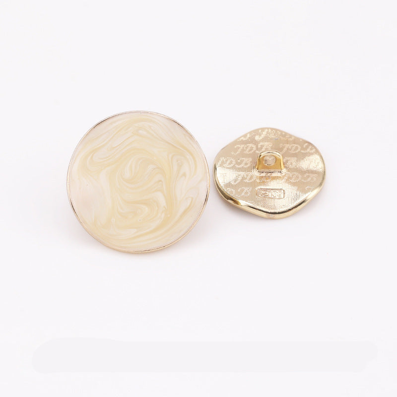Beige irregular dot oil coat button with metal shank; front and back view