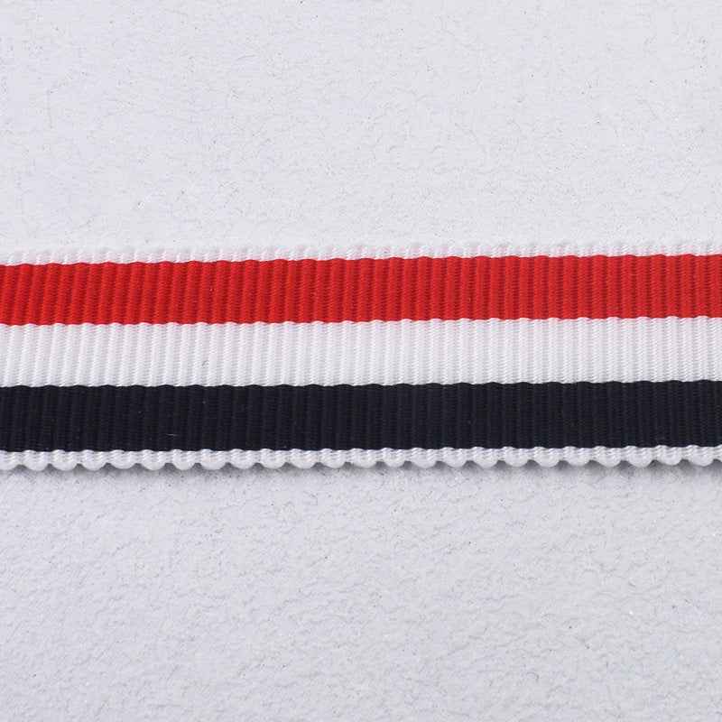 Detalle de cinta a rayas rojo, blanco y azul con franja negra y borde de hilo