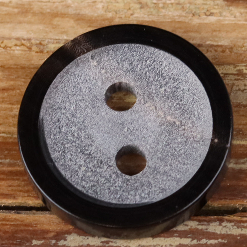 Two-hole round black horn button with gray-speckled rim and matte finish