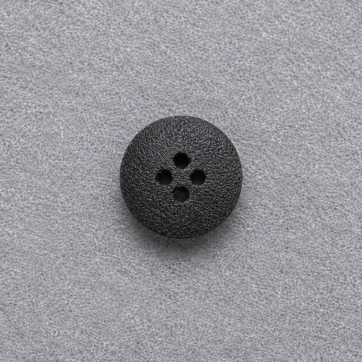 Dark brown flat round wood button with four holes and textured finish