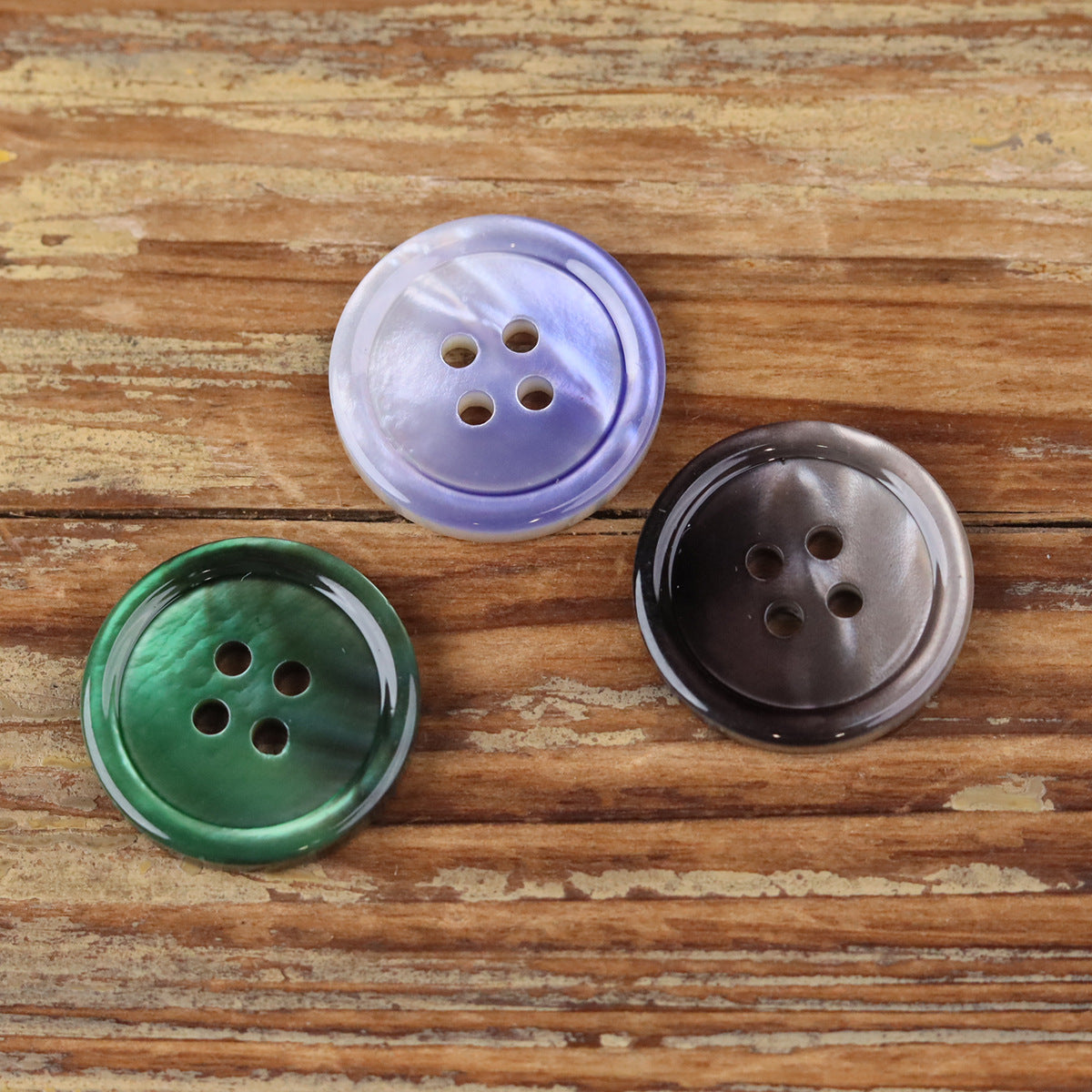 Round 4-hole shell-style buttons in lavender, green, and dark brown gradient tones