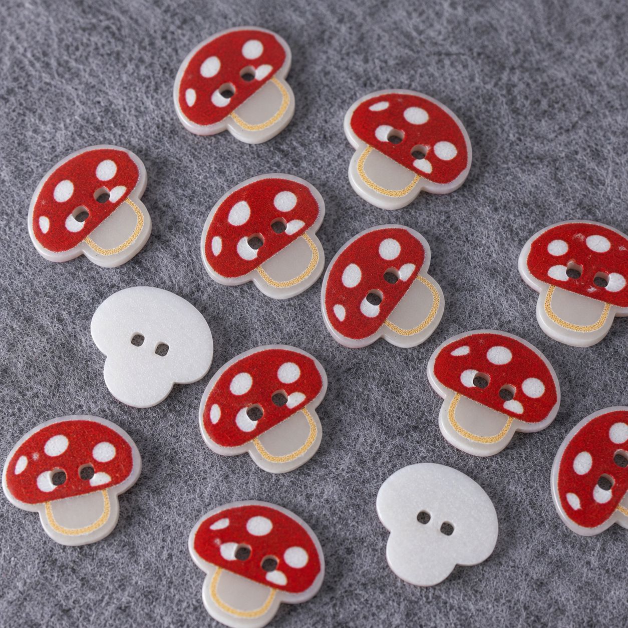 Set of mushroom resin buttons: red caps and white caps on gray felt