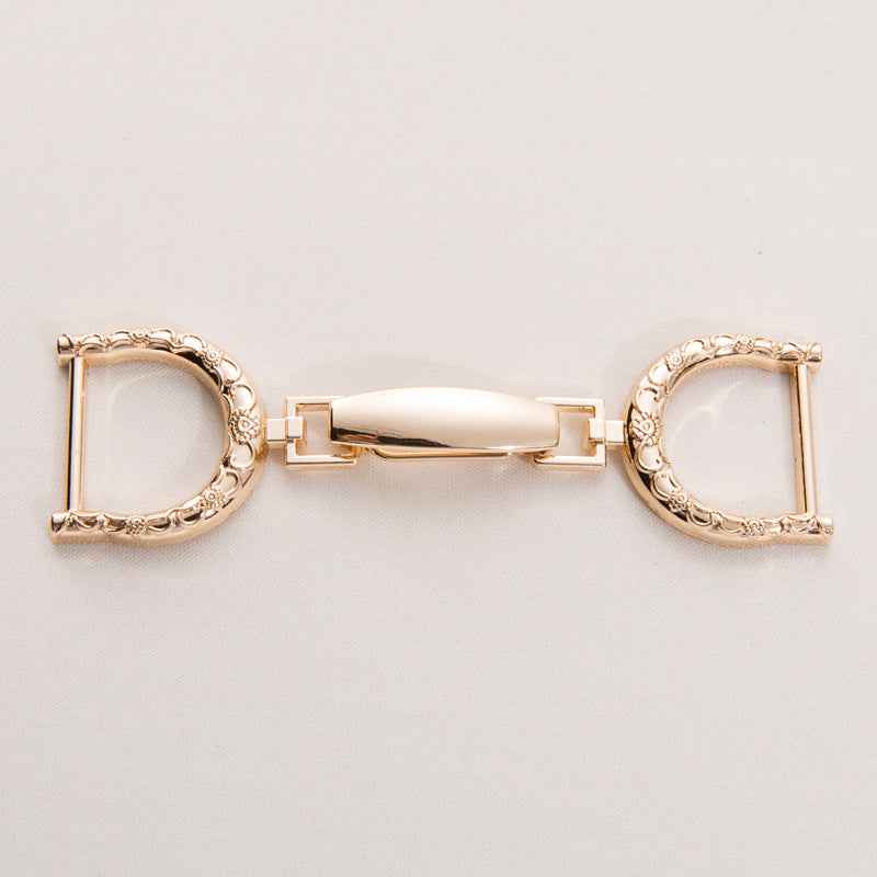 Oversized metal belt buckle clasp, gold-tone finish with ornate oval frame and central bar