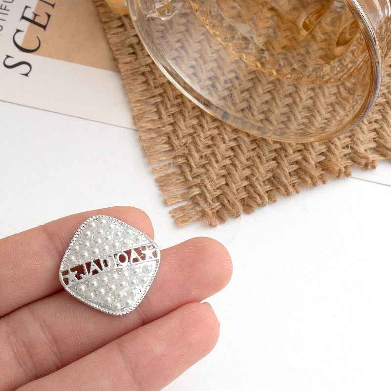 Gold square metal button with pearl-style studs and decorative geometric cutout