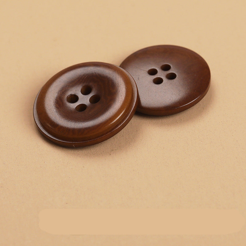 Two round 4-hole natural fruit shell buttons in dark brown, side-by-side