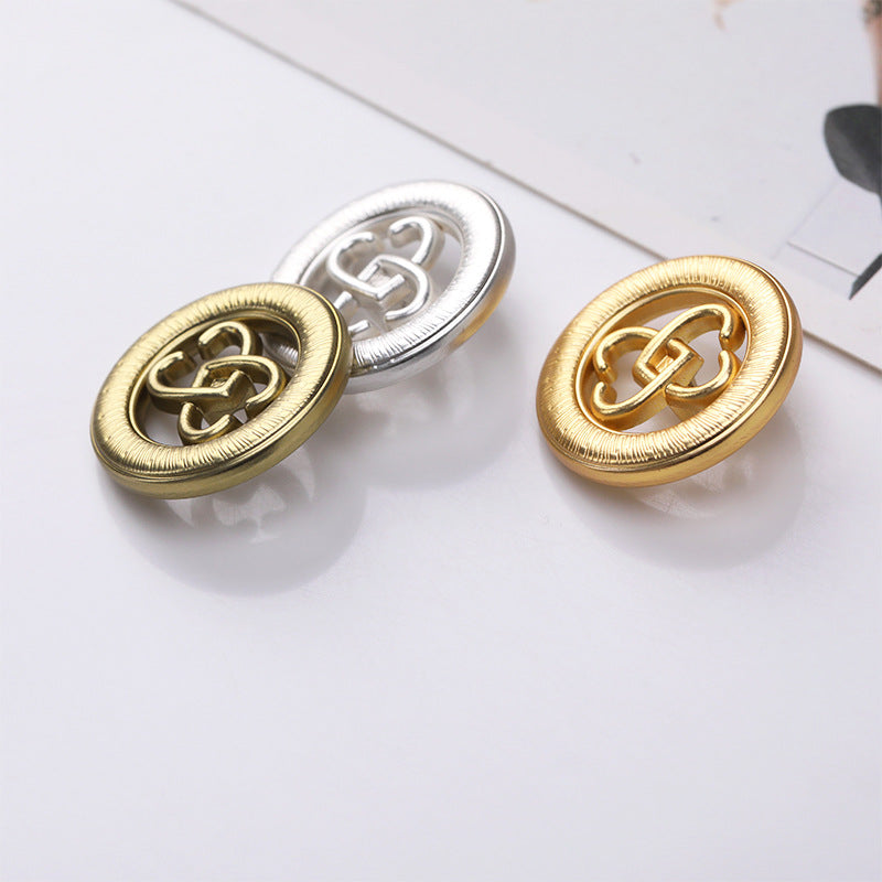 Gold and silver round double-heart hollow cutout metal shank buttons, angled view
