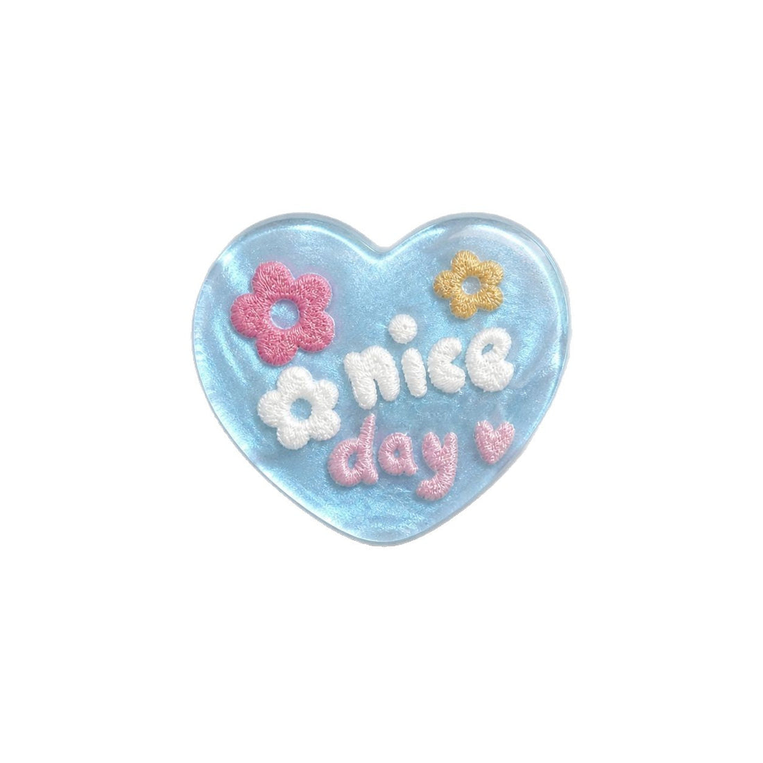 Heart-shaped resin button in light blue with “nice day” lettering and flower details