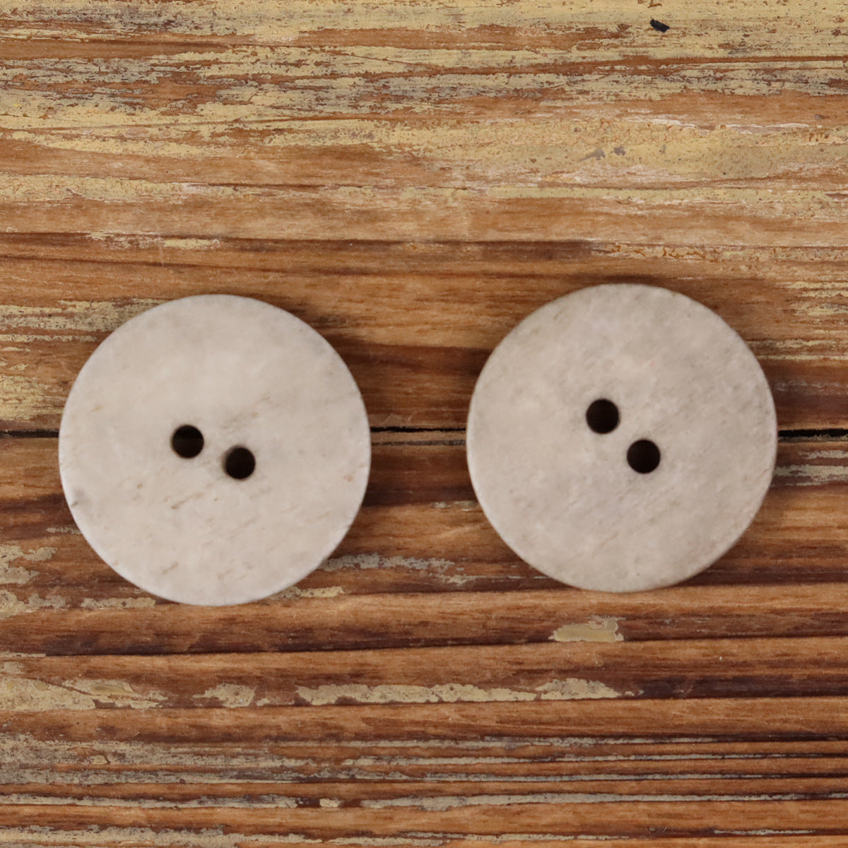 Light khaki natural bone round 2-hole domed buttons, two front views
