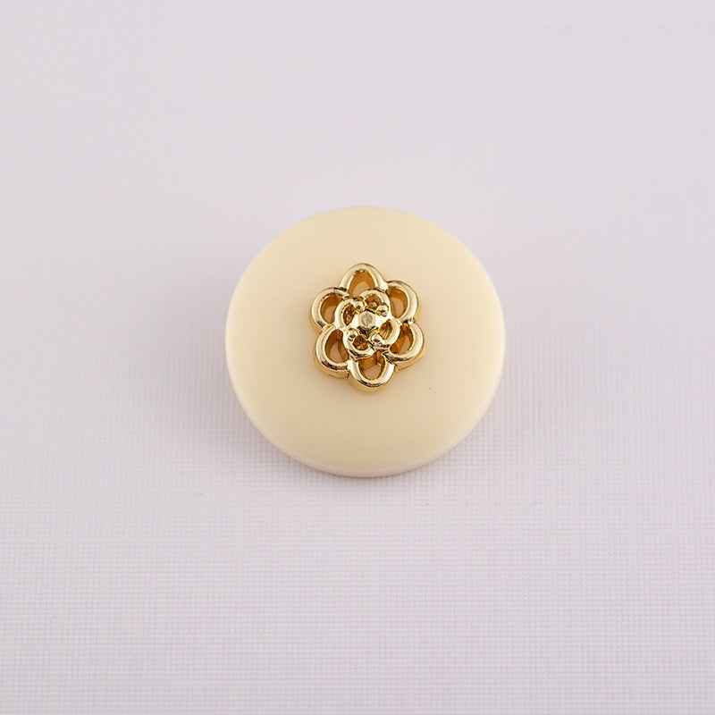 Beige round resin button with metal shank and gold decorative center