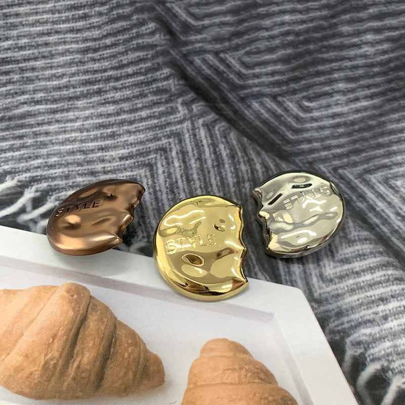 Semi-circular metal shank buttons in coffee, gold, and silver, engraved “STYLE”