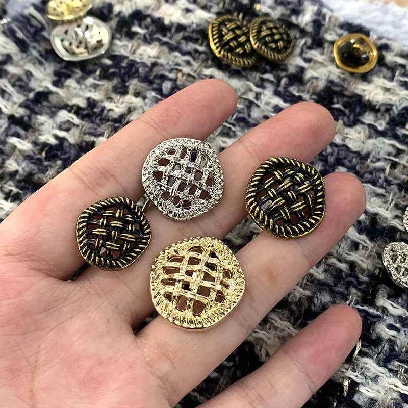 In der Hand: runde Zierknöpfe in Gold, Silber und Bronze mit hohlem Mesh