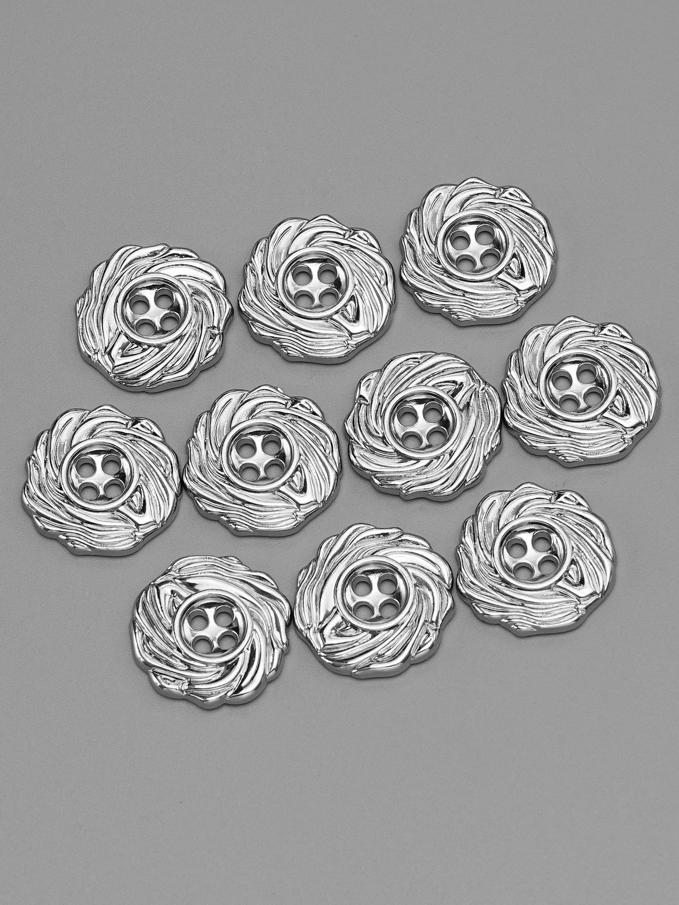 Silver 4-hole spiral metal buttons set, evenly spaced, front view