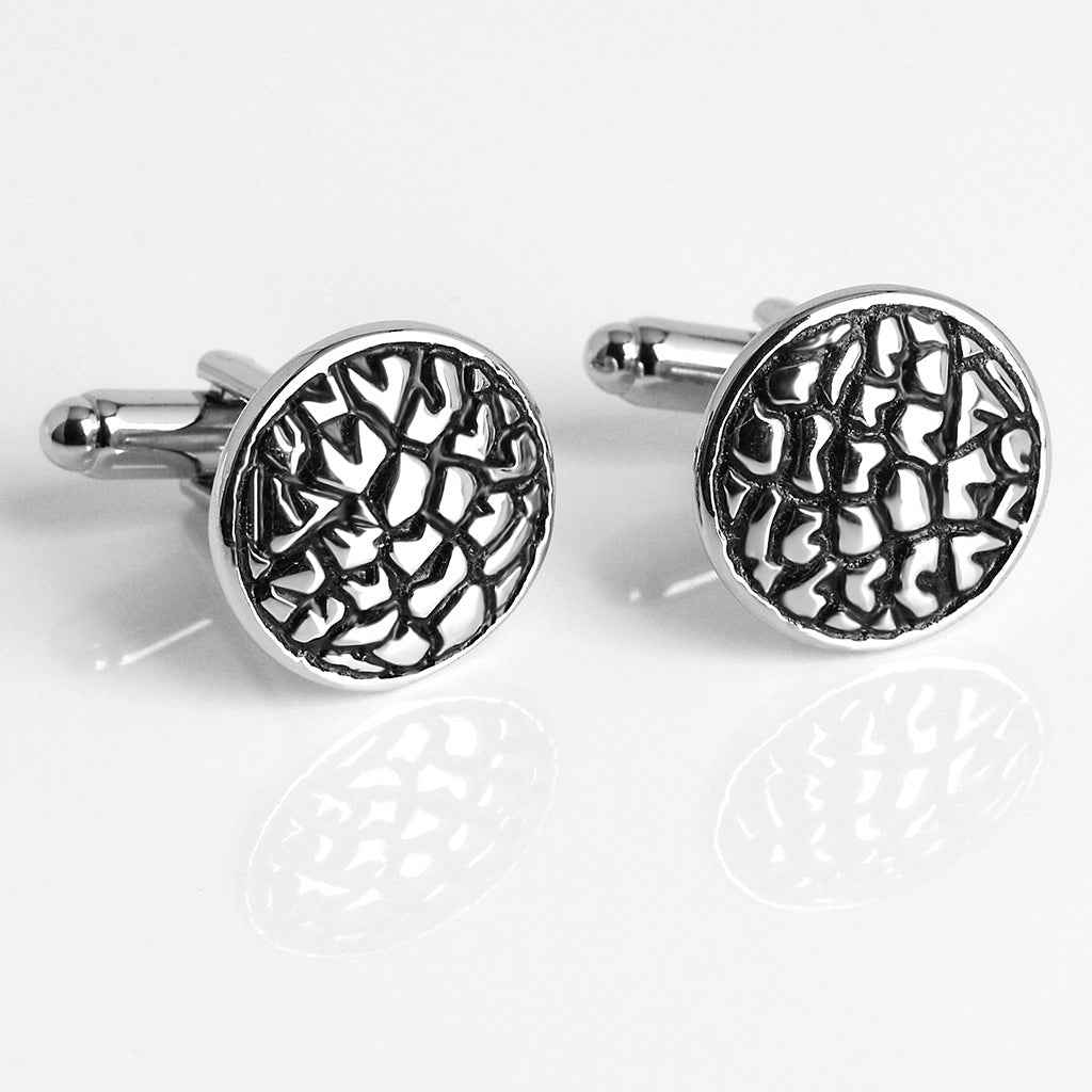Pair of round cufflinks with black enamel, branching ornate design on the front faces