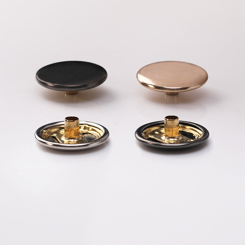 Curved snap buttons showing black dome and gold-toned base with post