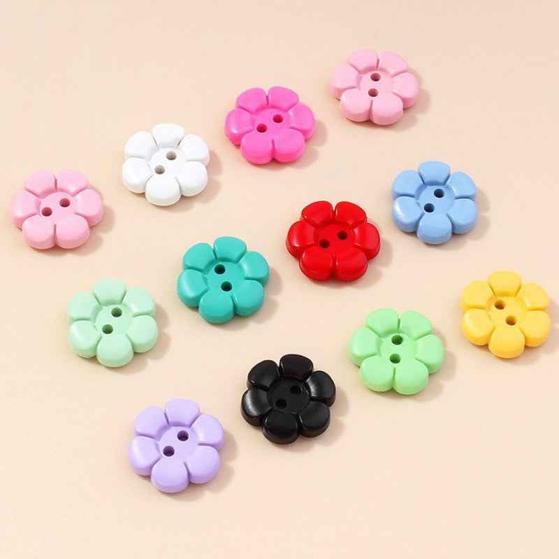 Mix of pastel and bright flower-shaped 2-hole plastic buttons, various colors