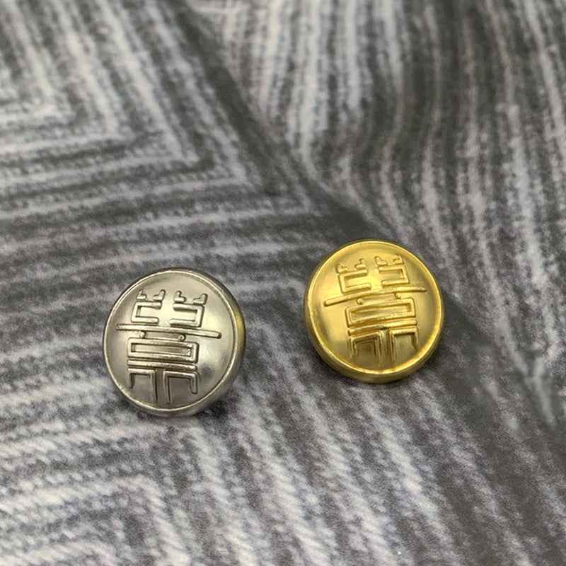 Silver and gold round mushroom-design button faces with embossed symbol details