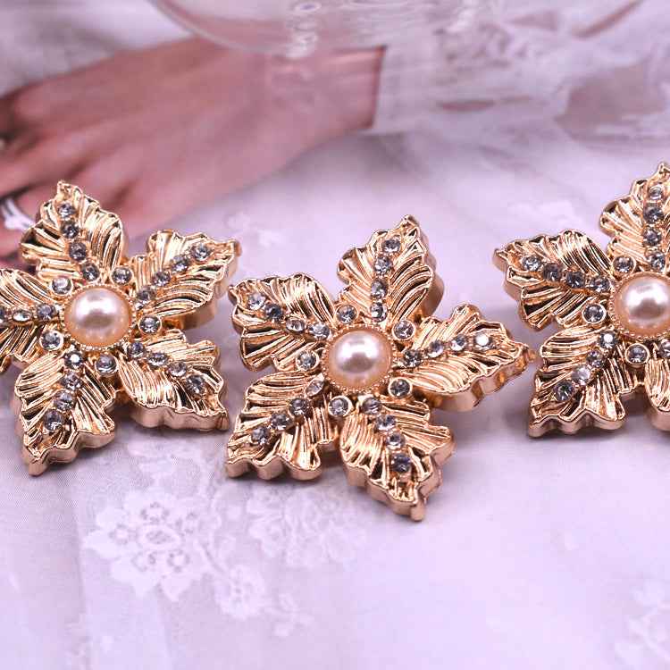 Gold snowflake cardigan button with faux pearl center and crystal-like rhinestones