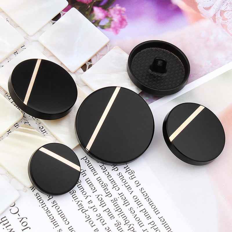 Black metal shank coat button, round face with gold-colored stripes