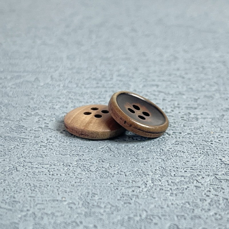 Four-hole wood buttons, one brown wooden face and one dark inset face.