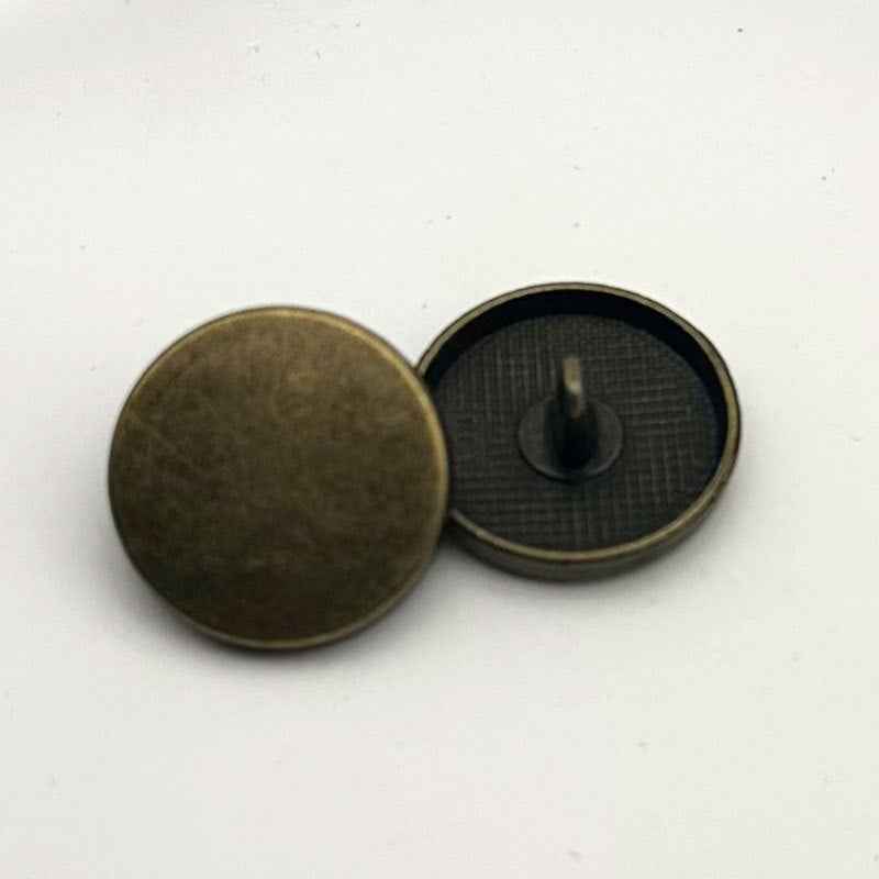Bronze round flat metal shank button, front face with visible loop back