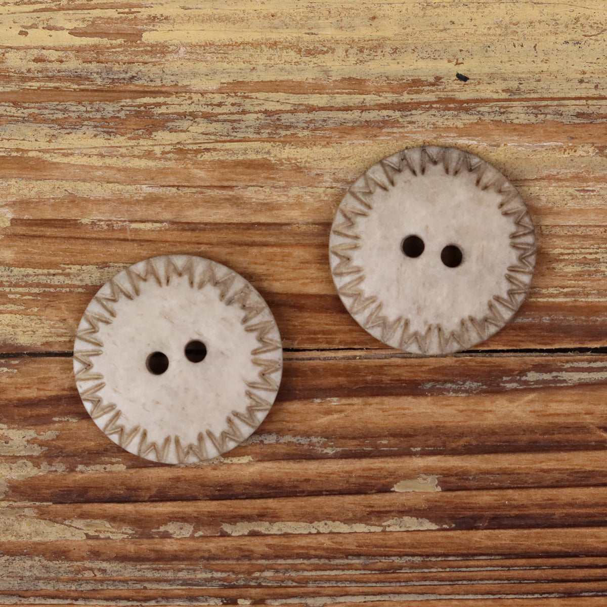 Light khaki natural bone round 2-hole domed buttons, two at angles