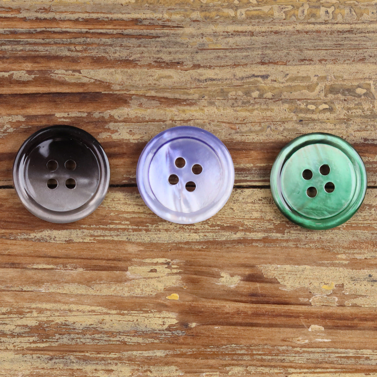 Round 4-hole shell-style buttons in dark grey, lavender, and green gradients