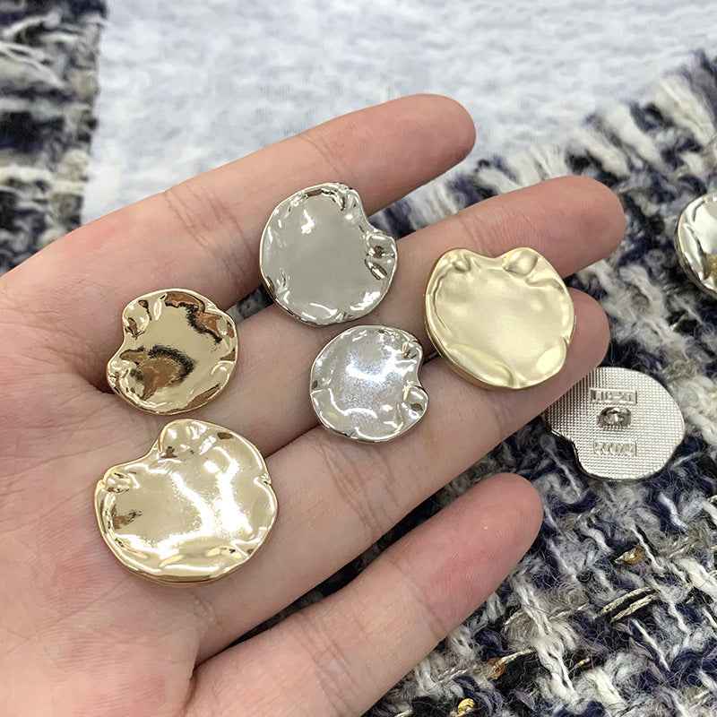 Irregular metal hand-sewn buttons held in hand: gold and silver discs, 18/21/23mm