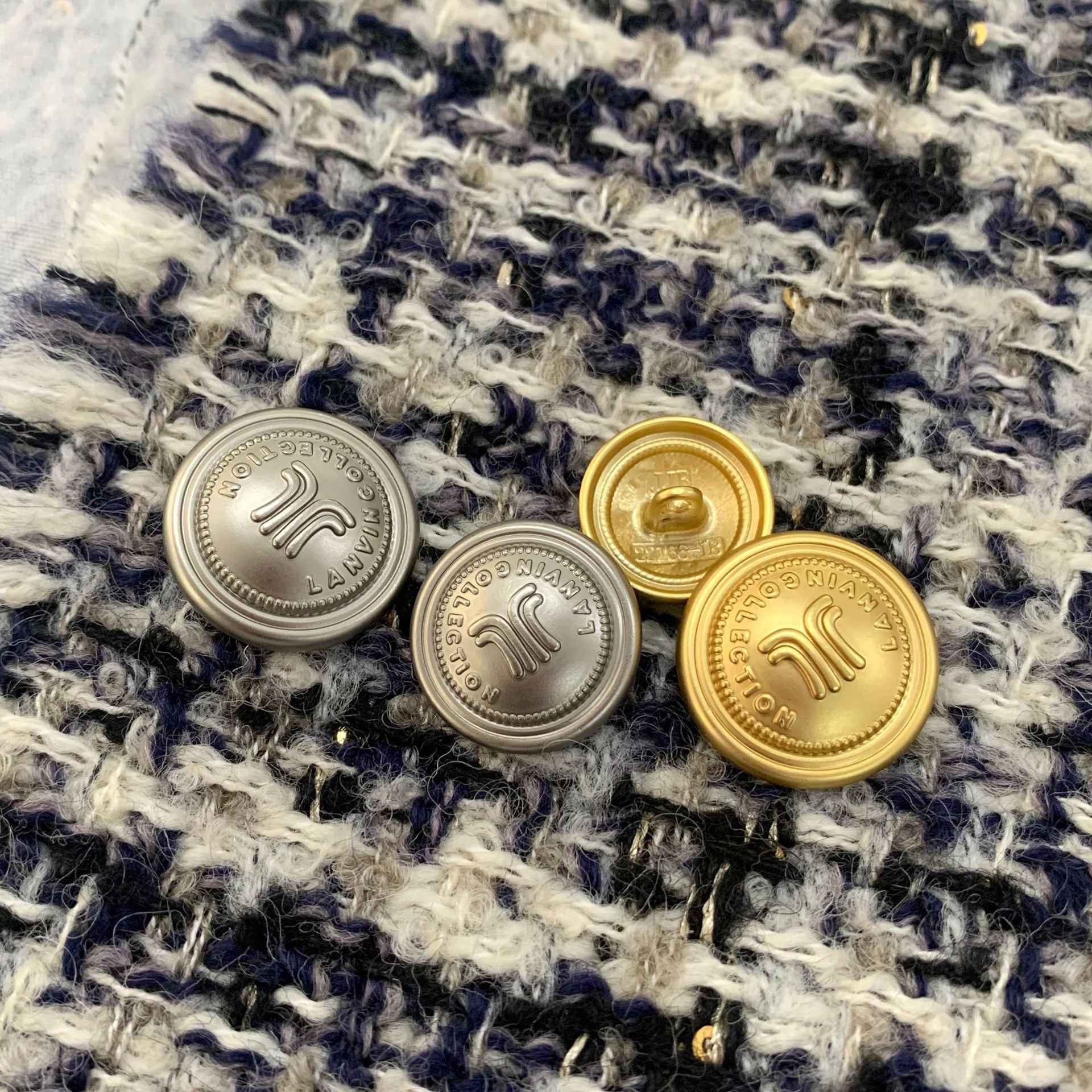 Frosted metal shank buttons in gold and silver, round with embossed motif