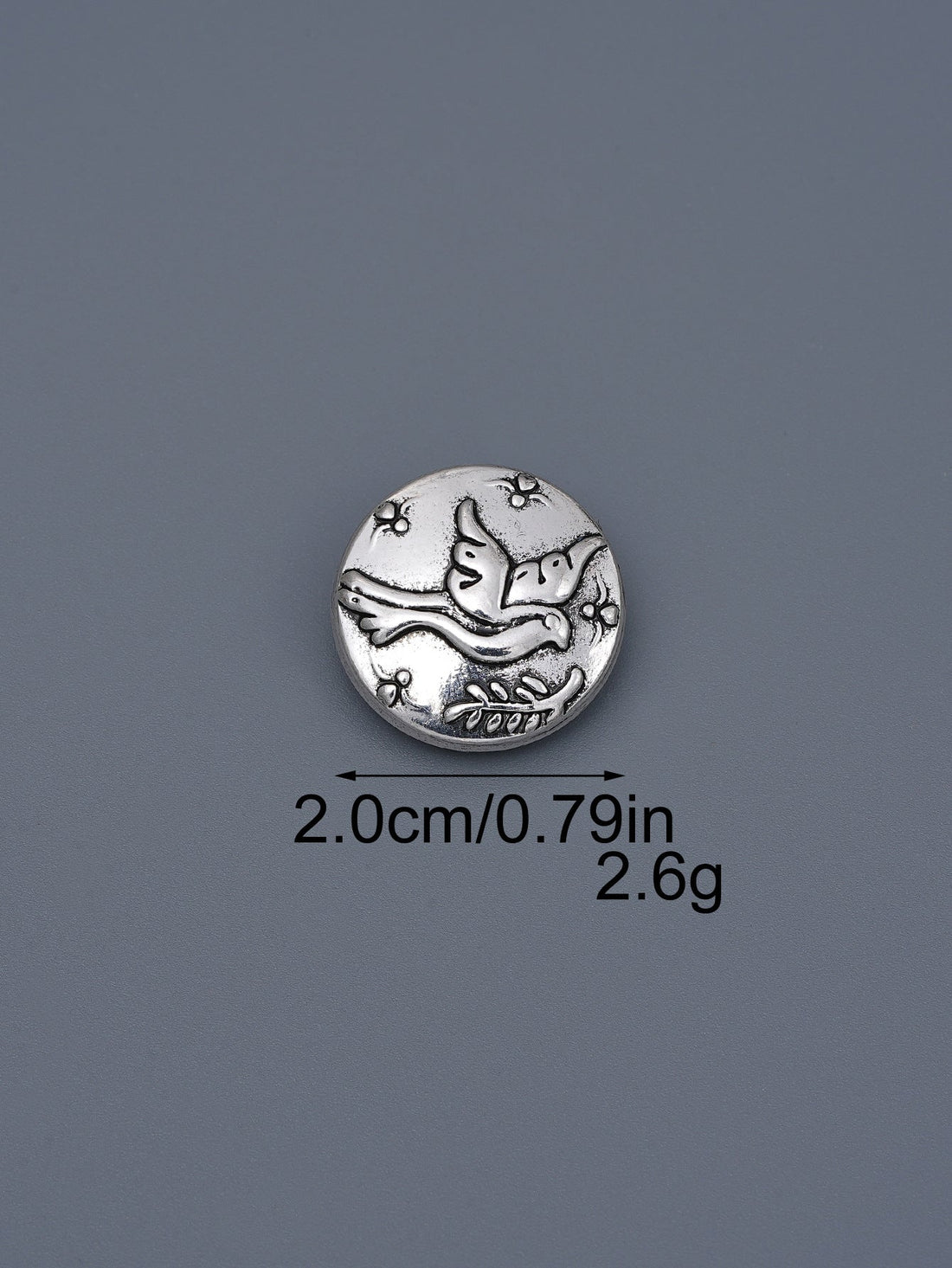 Silver-toned embossed metal shank button with flying bird design, ~2.0cm