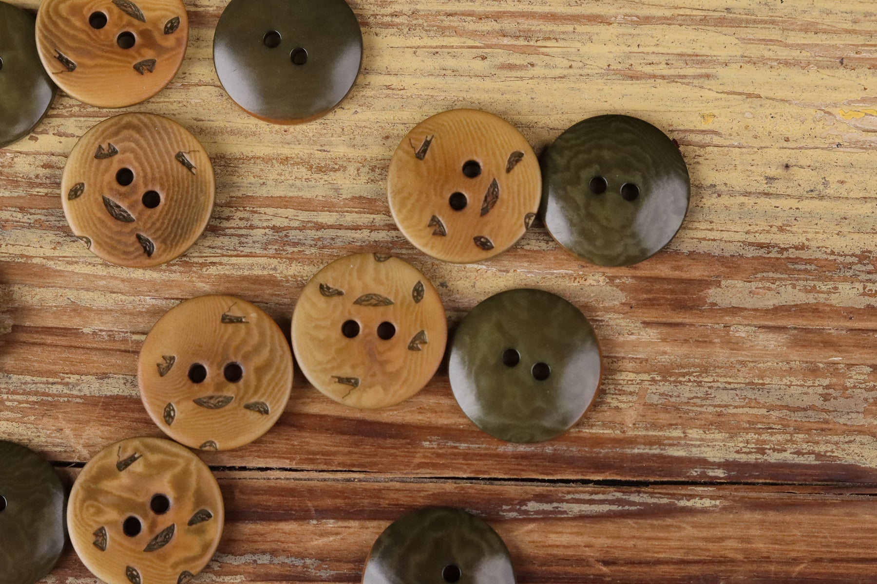 Round 2-hole buttons in tan and olive-brown tones with small printed motifs