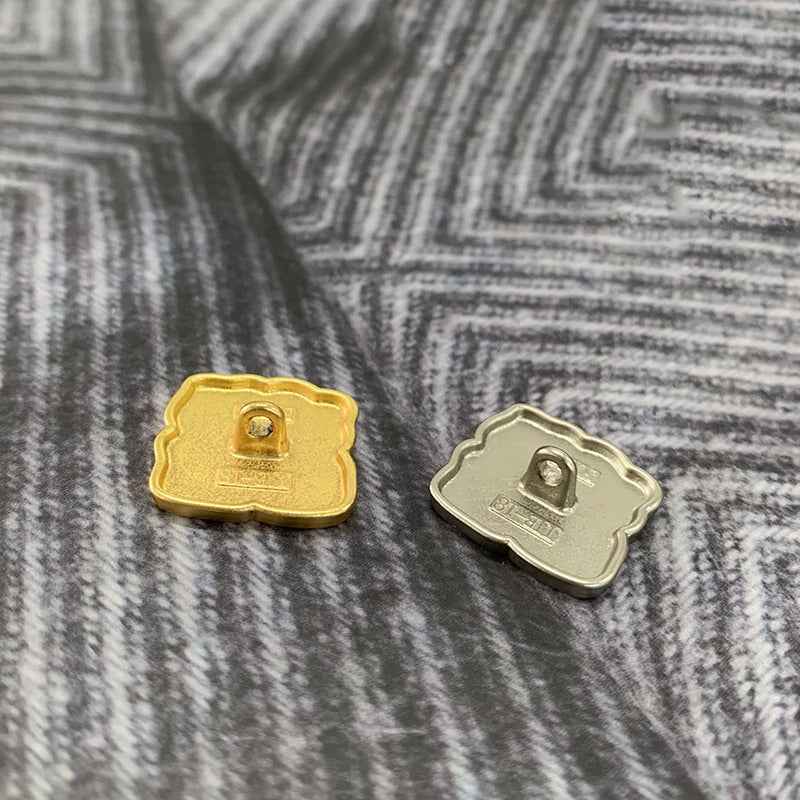 Back view of square Chinese-style metal buttons in matte gold and matte silver