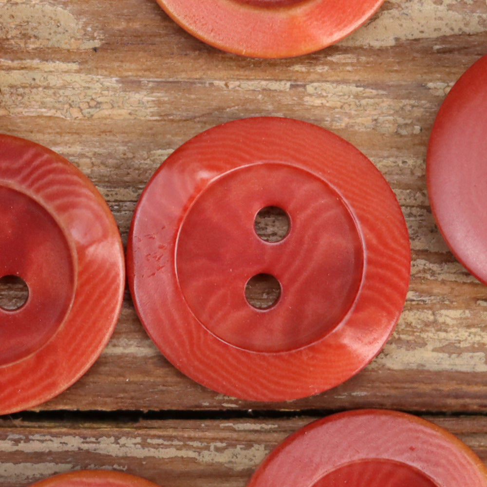 Red round 2-hole palm nut buttons with scorched rim edge and textured surface
